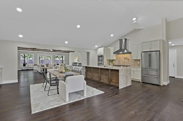 2727 Westmont Blvd, Columbus, OH 43221 - kitchen featuring stainless steel appliances, wall chimney exhaust hood, light countertops, backsplash, and an island with sink