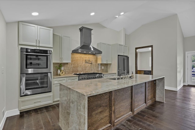 2727 Westmont Blvd, Columbus, OH 43221 - kitchen featuring appliances with stainless steel finishes, exhaust hood, light stone counters, dark wood-style flooring, and vaulted ceiling