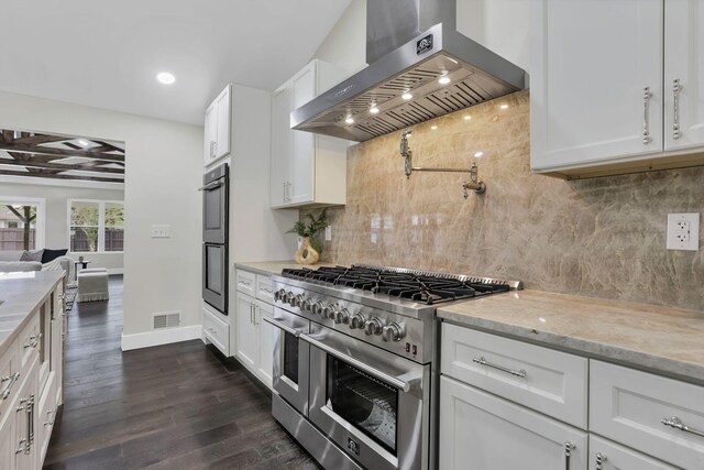 2727 Westmont Blvd, Columbus, OH 43221 - kitchen with stainless steel appliances, range hood, dark wood-style flooring, white cabinetry, and tasteful backsplash