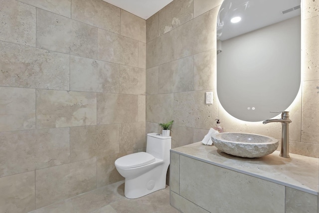 2727 Westmont Blvd, Columbus, OH 43221 - half bath with tile walls, toilet, tile patterned flooring, and vanity
