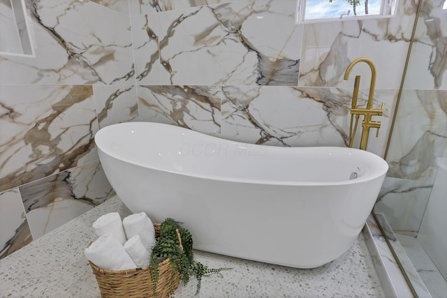 2727 Westmont Blvd, Columbus, OH 43221 - bathroom with stone wall and a freestanding tub