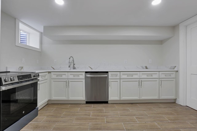 2727 Westmont Blvd, Columbus, OH 43221 - kitchen with stainless steel appliances, a sink, wood tiled floors, white cabinets, and light countertops