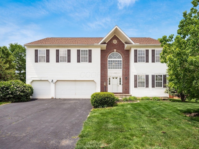view of front of home with a garage, driveway, and a front yard