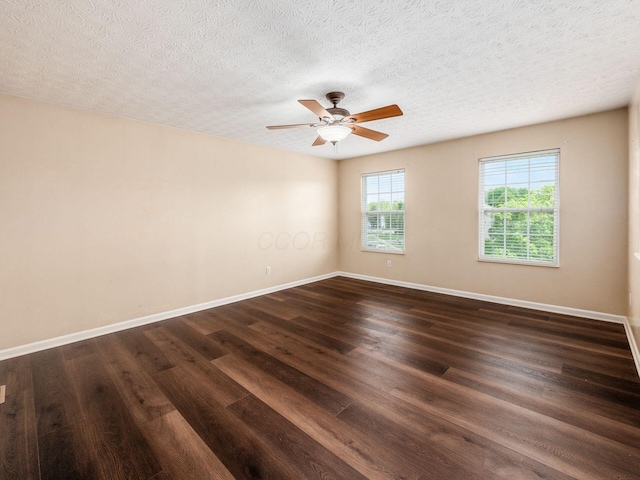 empty room with dark wood finished floors, ceiling fan, baseboards, and a textured ceiling