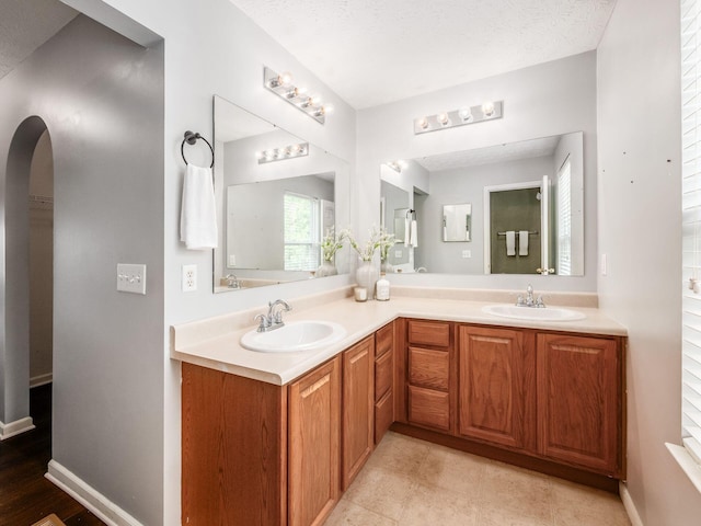 full bathroom with double vanity and baseboards