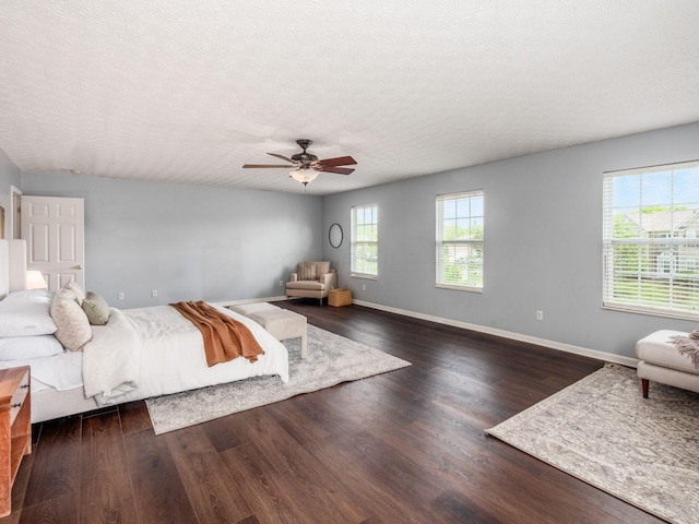 bedroom featuring wood finished floors, a textured ceiling, baseboards, and ceiling fan