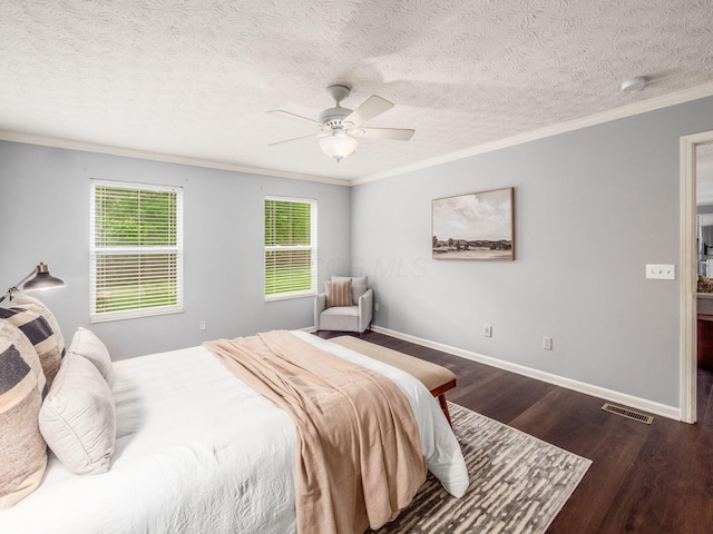 bedroom featuring crown molding, dark wood-style floors, ceiling fan, a textured ceiling, and baseboards