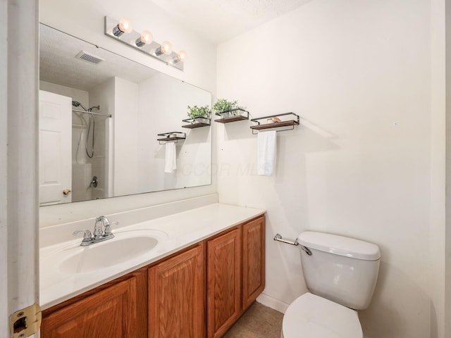 bathroom featuring toilet, a shower, vanity, tile patterned floors, and a textured ceiling