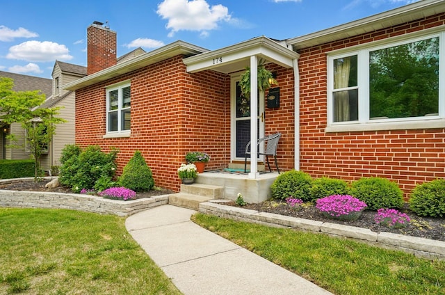 view of front facade featuring brick siding and a chimney