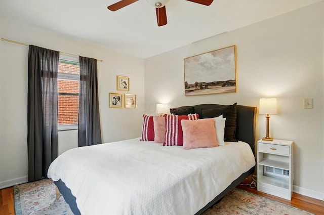bedroom featuring wood finished floors, baseboards, and ceiling fan