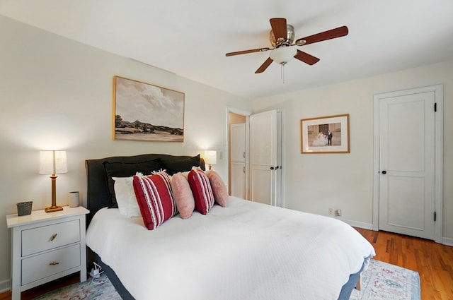 bedroom with wood finished floors, ceiling fan, and baseboards
