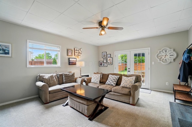 carpeted living room featuring a ceiling fan, french doors, and baseboards