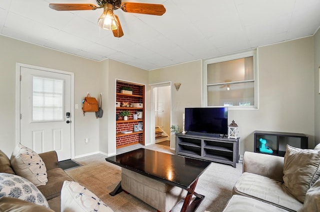 carpeted living room with a ceiling fan, baseboards, and built in features