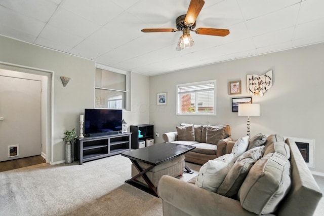 living area featuring ceiling fan, carpet, and baseboards