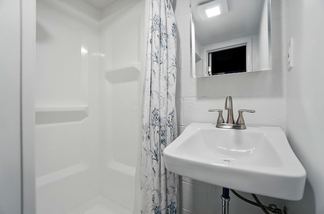 bathroom featuring a sink and a shower stall