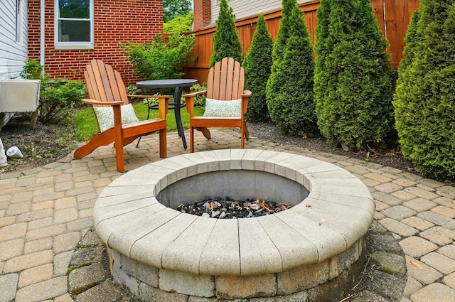 view of patio with an outdoor fire pit and fence