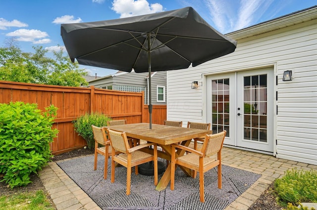 view of patio / terrace featuring french doors, fence, and outdoor dining area