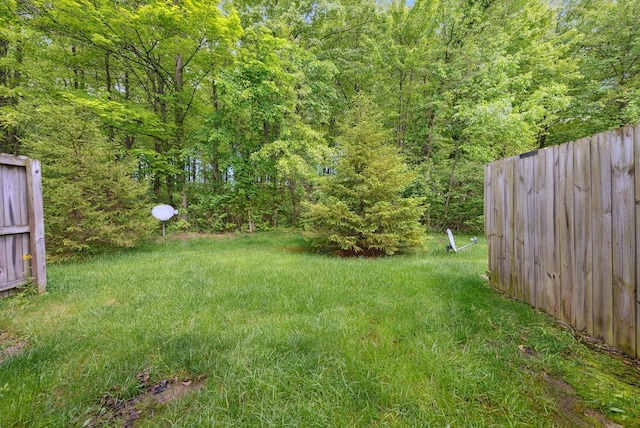 view of yard with fence and a forest view