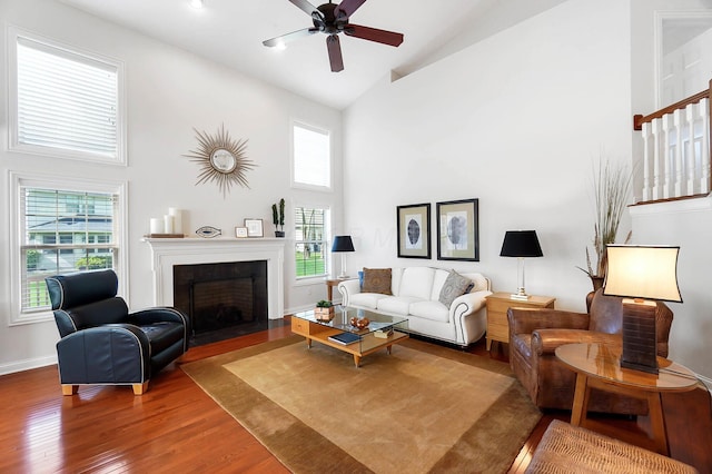 6415 Green Stone Loop, Dublin, OH 43016 - living room featuring high vaulted ceiling, wood finished floors, ceiling fan, a fireplace with flush hearth, and baseboards