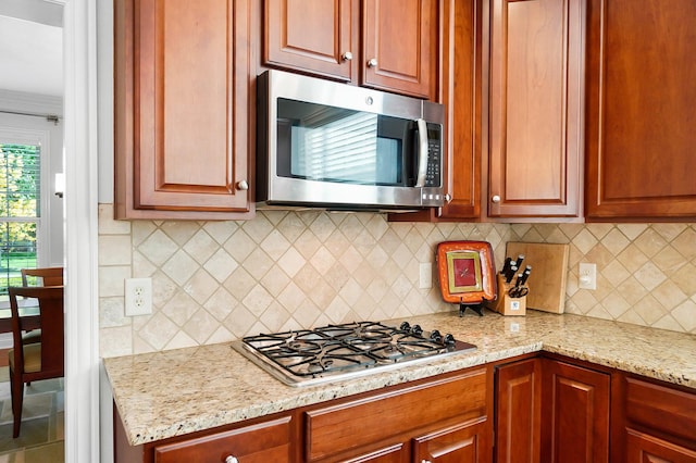 6415 Green Stone Loop, Dublin, OH 43016 - kitchen with stainless steel appliances, light stone counters, and backsplash