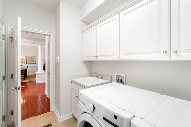 6415 Green Stone Loop, Dublin, OH 43016 - laundry area with cabinet space, ornate columns, washing machine and clothes dryer, baseboards, and light tile patterned flooring