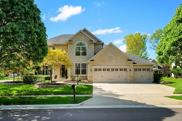 6415 Green Stone Loop, Dublin, OH 43016 - traditional-style house with a garage, stone siding, stucco siding, a front lawn, and driveway