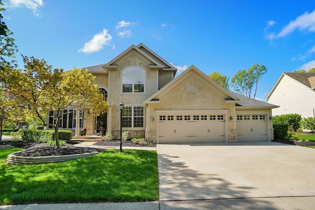 6415 Green Stone Loop, Dublin, OH 43016 - view of front facade featuring an attached garage, driveway, stone siding, stucco siding, and a front yard