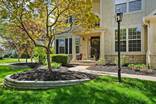 6415 Green Stone Loop, Dublin, OH 43016 - entrance to property featuring stone siding, a lawn, and stucco siding