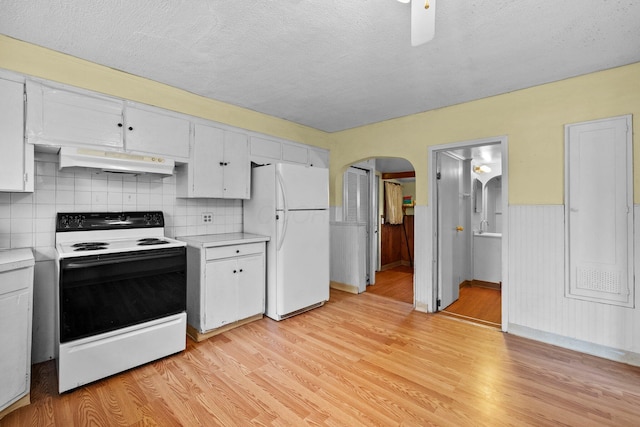 616 E Chestnut St, Mount Vernon, OH 43050 - kitchen featuring range with electric cooktop, freestanding refrigerator, under cabinet range hood, arched walkways, and light countertops