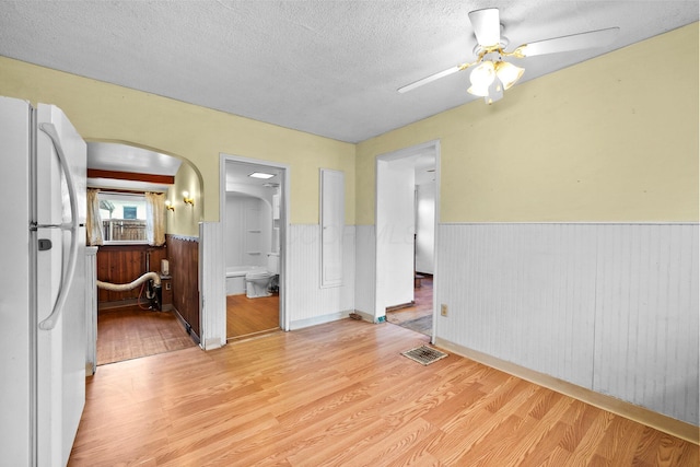 616 E Chestnut St, Mount Vernon, OH 43050 - spare room with a wainscoted wall, arched walkways, a textured ceiling, ceiling fan, and wood finished floors
