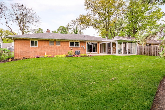 316 Charleston Ave, Columbus, OH 43214 - back of house with a sunroom, brick siding, a chimney, and central AC unit