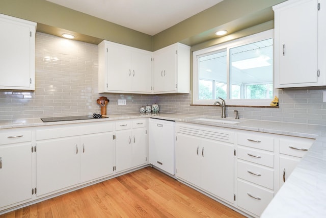 316 Charleston Ave, Columbus, OH 43214 - kitchen with white dishwasher, a sink, black electric stovetop, light countertops, and backsplash