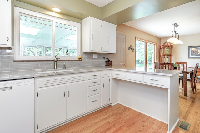 316 Charleston Ave, Columbus, OH 43214 - kitchen featuring dishwasher, a sink, light wood-style floors, decorative backsplash, and light countertops