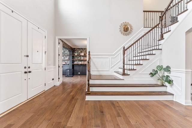 6540 Marshview Dr, Hilliard, OH 43026 - foyer entrance with a decorative wall, a high ceiling, stairs, wood-type flooring, and wainscoting