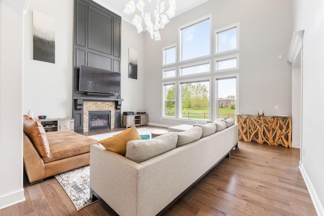6540 Marshview Dr, Hilliard, OH 43026 - living area with a towering ceiling, light wood finished floors, baseboards, a fireplace, and a chandelier