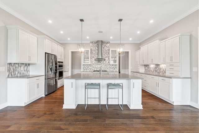 6540 Marshview Dr, Hilliard, OH 43026 - kitchen with stainless steel appliances, wall chimney exhaust hood, decorative backsplash, a center island with sink, and white cabinets