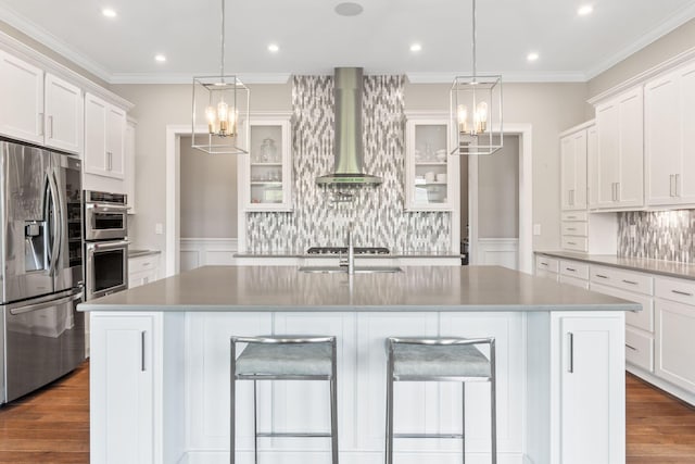 6540 Marshview Dr, Hilliard, OH 43026 - kitchen with appliances with stainless steel finishes, wall chimney exhaust hood, tasteful backsplash, a breakfast bar, and crown molding