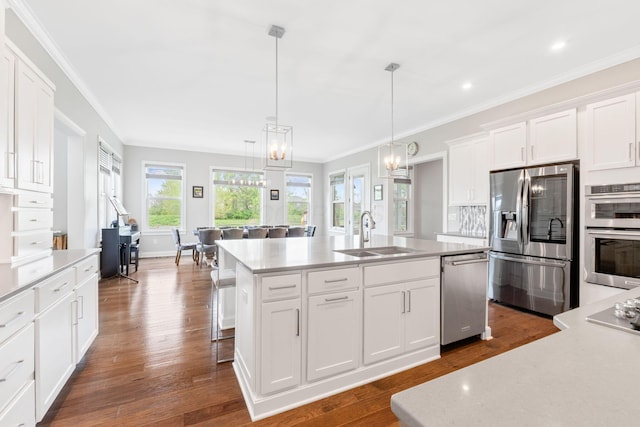 6540 Marshview Dr, Hilliard, OH 43026 - kitchen with stainless steel appliances, a sink, a center island with sink, ornamental molding, and white cabinets