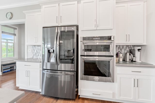 6540 Marshview Dr, Hilliard, OH 43026 - kitchen with stainless steel appliances, backsplash, white cabinets, light countertops, and wood finished floors