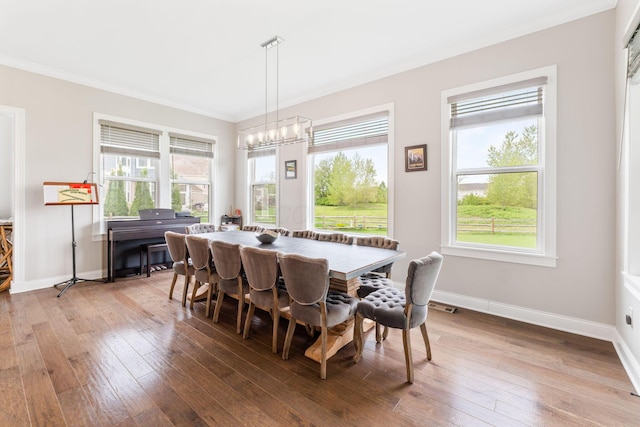 6540 Marshview Dr, Hilliard, OH 43026 - dining area with crown molding, hardwood / wood-style floors, baseboards, and a chandelier
