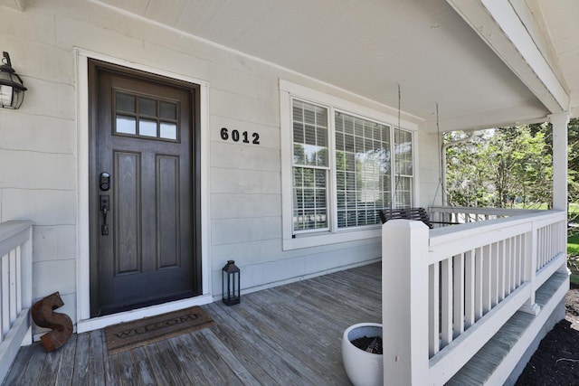 view of exterior entry featuring covered porch