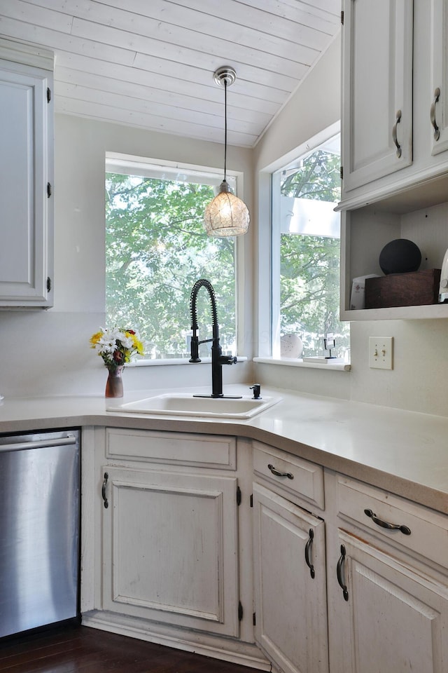 kitchen with stainless steel dishwasher, a sink, wooden ceiling, light countertops, and hanging light fixtures