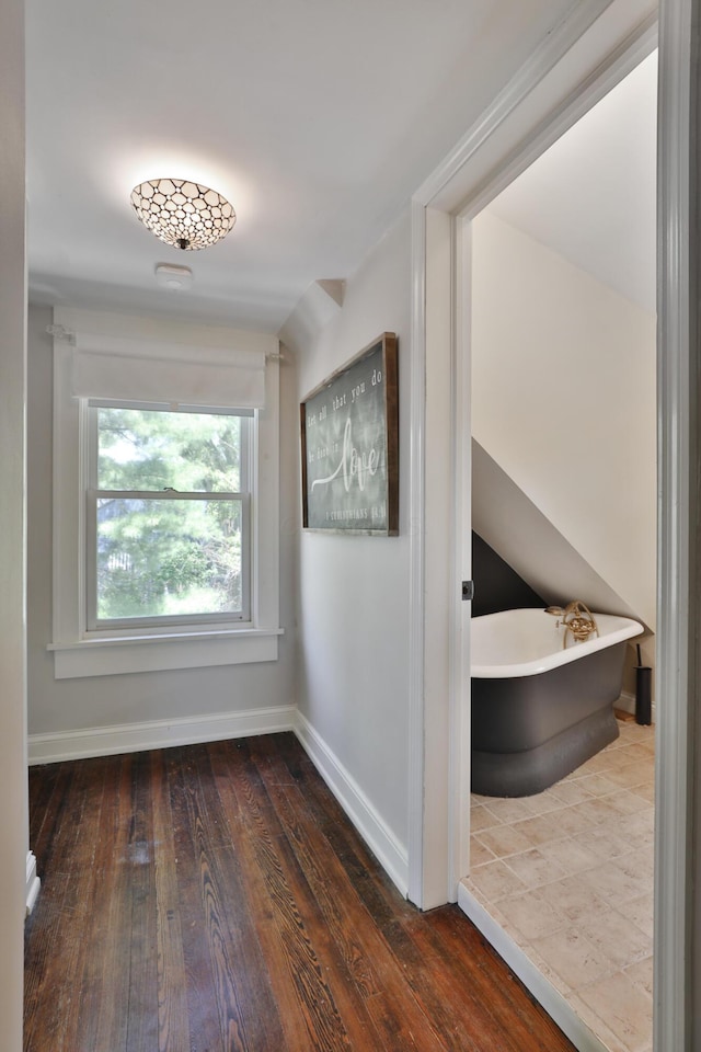 hall with hardwood / wood-style flooring and baseboards