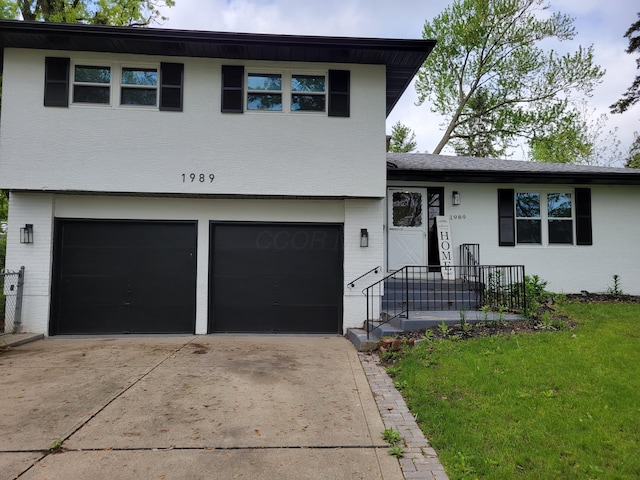 1989 Torchwood Dr, Columbus, OH 43229 - tri-level home featuring an attached garage, brick siding, a front yard, and driveway