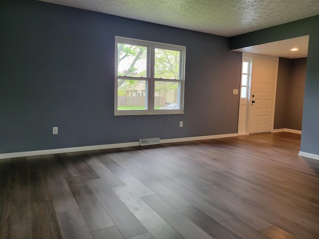 1989 Torchwood Dr, Columbus, OH 43229 - unfurnished room featuring dark wood-style flooring, healthy amount of natural light, baseboards, and a textured ceiling