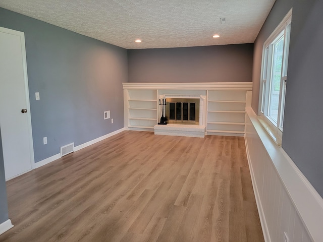 1989 Torchwood Dr, Columbus, OH 43229 - unfurnished living room featuring a textured ceiling, light wood-style flooring, a fireplace, and recessed lighting