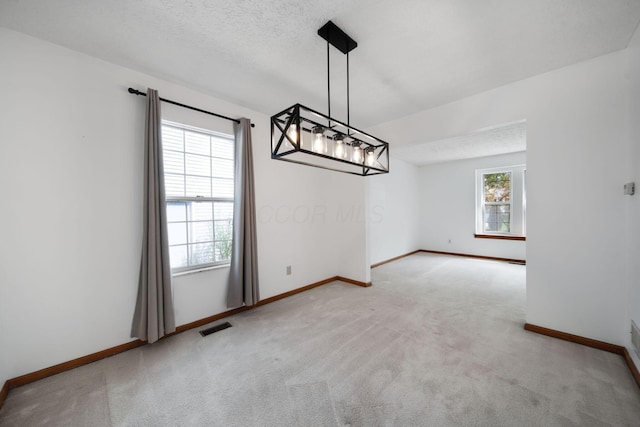 unfurnished dining area with carpet flooring and baseboards
