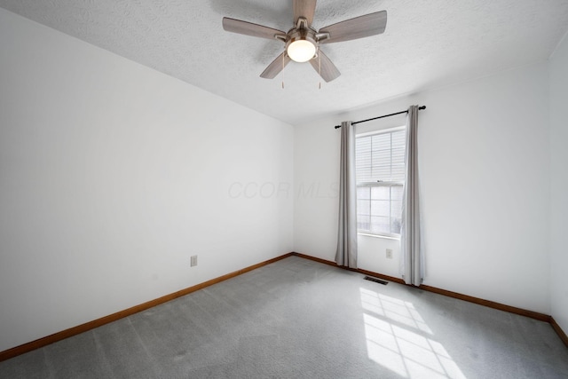 carpeted spare room with baseboards, a textured ceiling, and ceiling fan