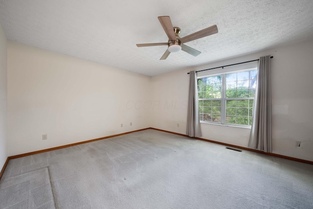 spare room featuring ceiling fan, baseboards, carpet, and a textured ceiling