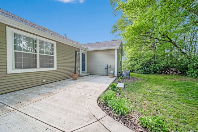 back of property with central air condition unit, a patio area, and a lawn